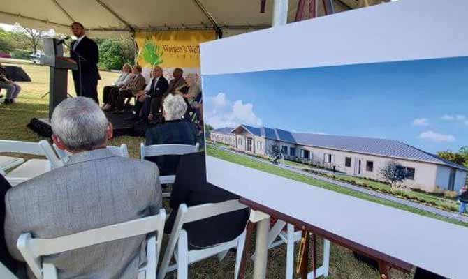 An artist's rendering of the new Casa Mia facility at the Women's Wellness Campus, foreground, is displayed at the campus groundbreaking event, with Bexar County Precinct 4 Commissioner Tommy Calvert speaking, background.