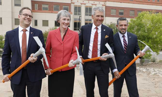 Group photo of UT System and UT El Paso leadership holding branded miner pic-axes for a ground breaking
