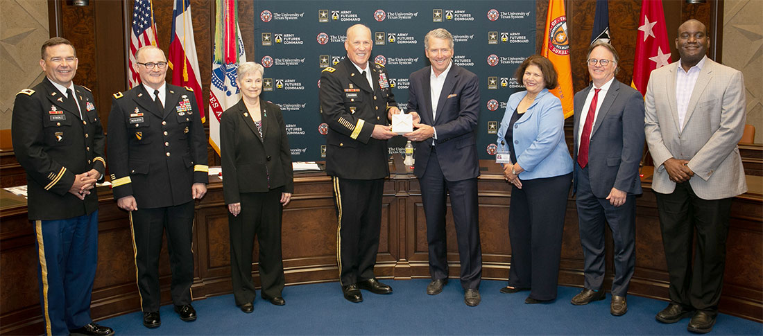 Leaders from the UT System, AFC, U.S. Army Institute of Surgical Research (USAISR), and U.S. Army Medical Research Command in a group photo holding a document
