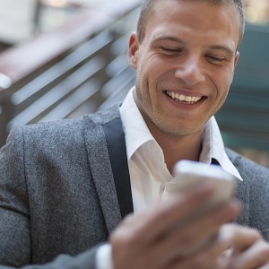 Close up of man wearing suit jacket looking at his cell phone.