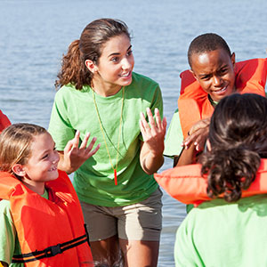 Children in life jackets with adult instructor.