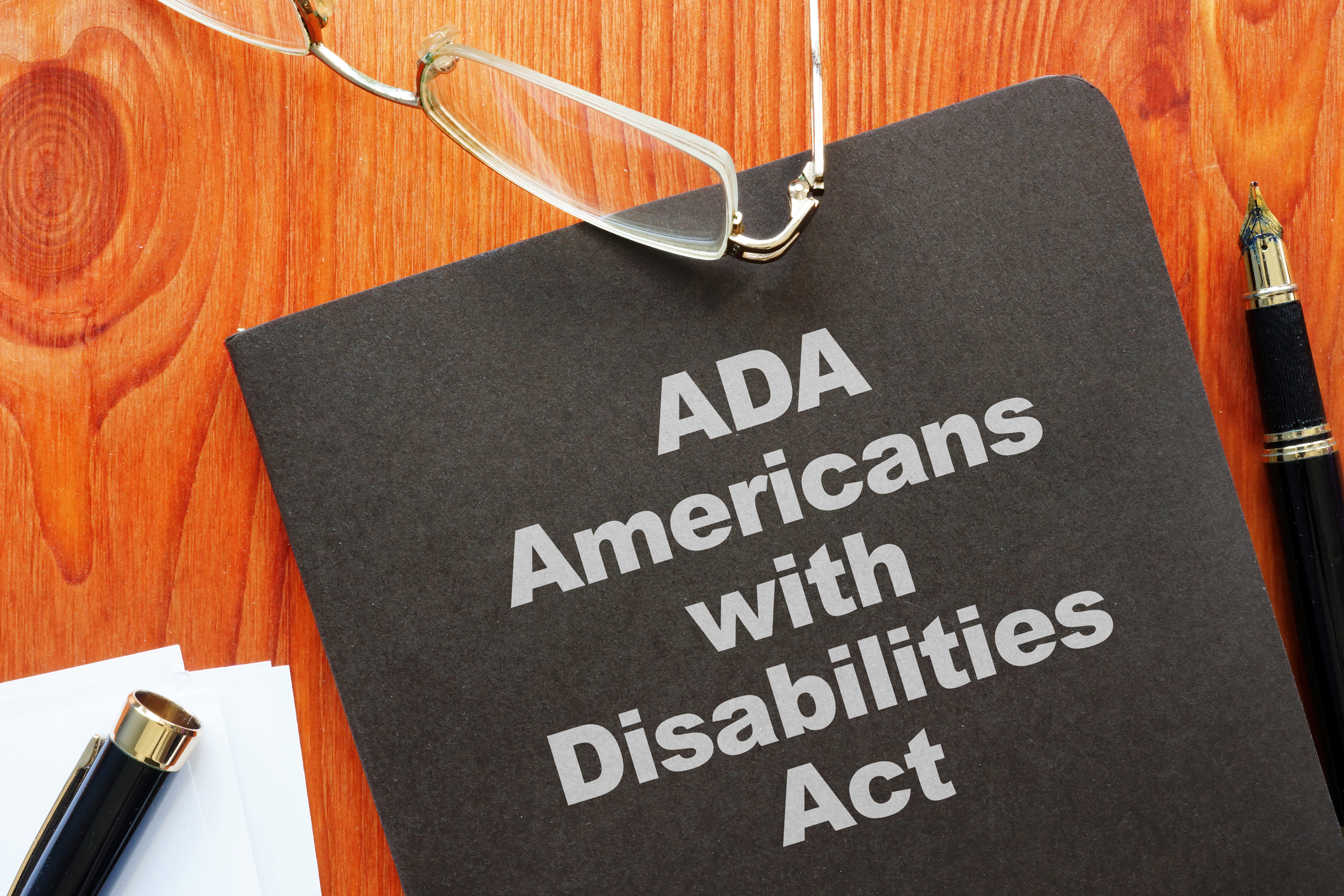 Book on a table with glasses. The text says Americans with Disabilities Act.