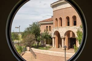 Looking through a circle window at the Laredo facade