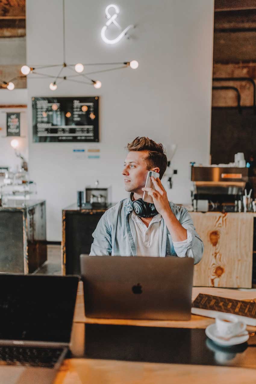 Person at a desk and laptop, with headphones one