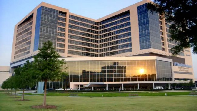 UT Southwestern front of the building during sunset, with the sun reflecting off some of the windows on the bottom