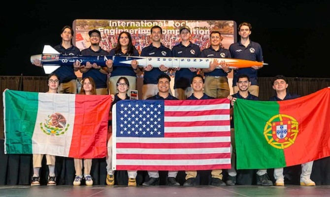 The Sun City Rocket Team celebrates their success at the International Rocket Engineering Competition with the flags of (from left) Mexico, the United States and Portugal to represent the students' countries of origin.