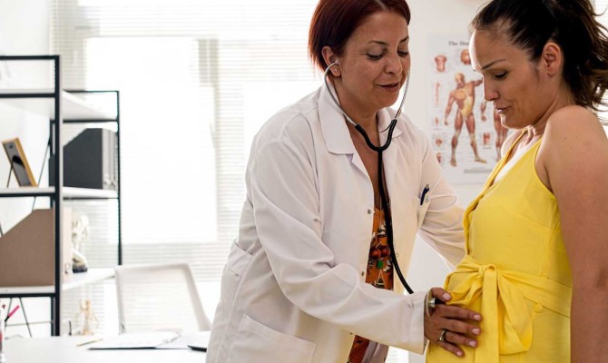 Happy pregnant woman visit gynecologist doctor at hospital or medical clinic for pregnancy consultant.