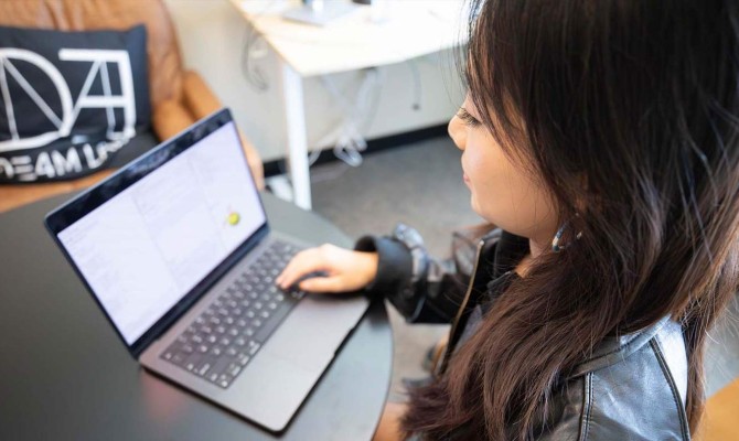 Female student working on her laptop, looking at the screen