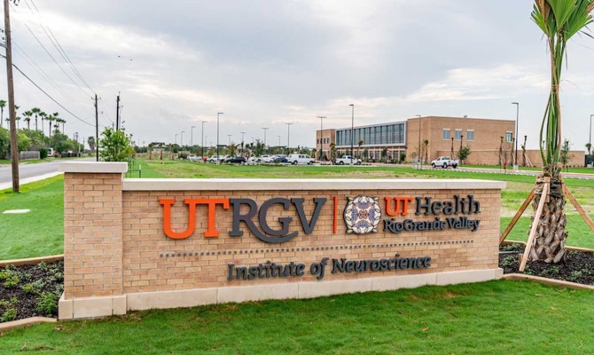 A brick UTRGV sign reading “UT Health Rio Grande Valley Institute of Neuroscience” stands on a green campus lawn