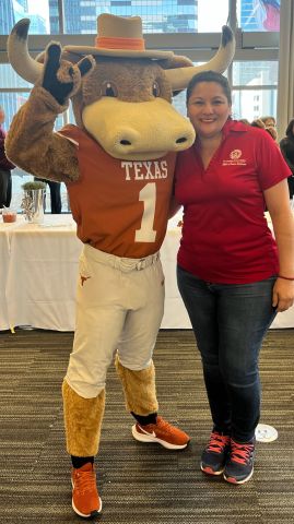 Georgina "Gina" Arevalo, UT System's Benefits and Wellness Program Coordinator in the Office of Talent and Innovation, poses with Bevo. 