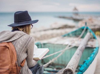 A traveler reading a book, preparing for a journey