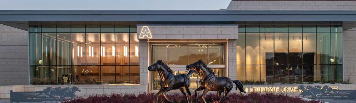 Front facade of the E.H. Hereford center, feature a statue of two galloping horses in front of the entrance